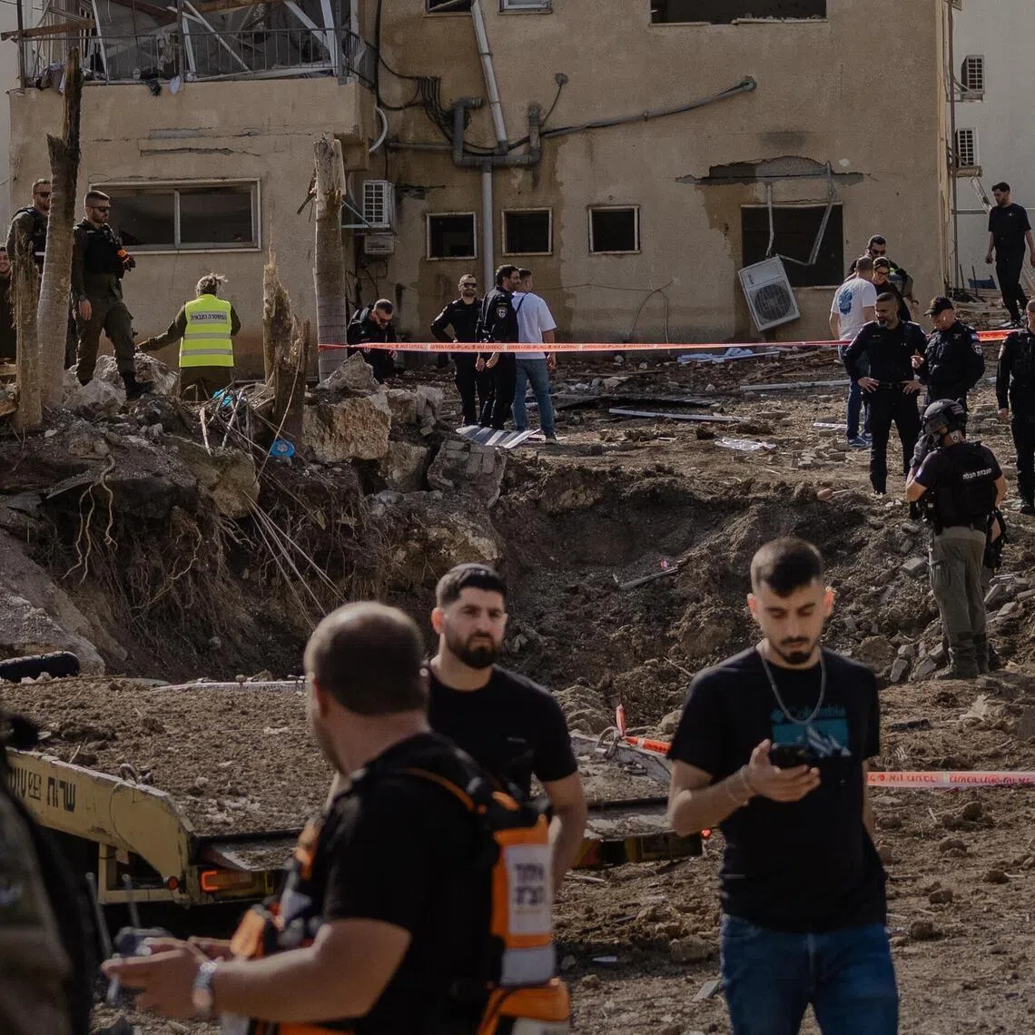 Emergency responders at the site of a strike in the town of Eshtaol, Israel.
