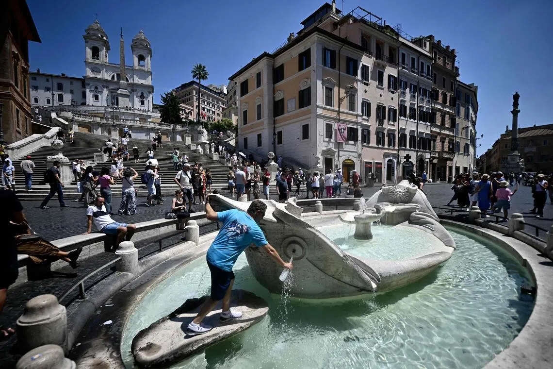 A man fills a bottle of water at the Barcaccia fountain near the Spanish Steps during an early-season heatwave in Rome.

