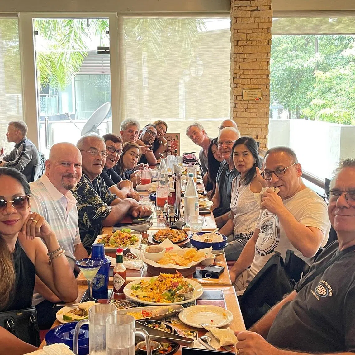 Several foreign retirees who are part of Mr Steven Johnson's expat support group eats at an American cuisine restaurant in the Philippines on December 14, 2022. 