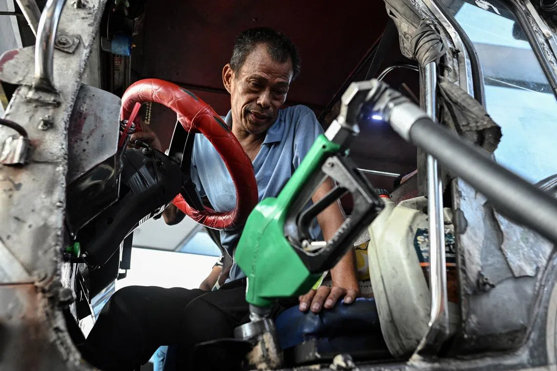 A driver in the Philippines refills his jeep with diesel. The Philippines grappling with shortages caused by the Iran war.