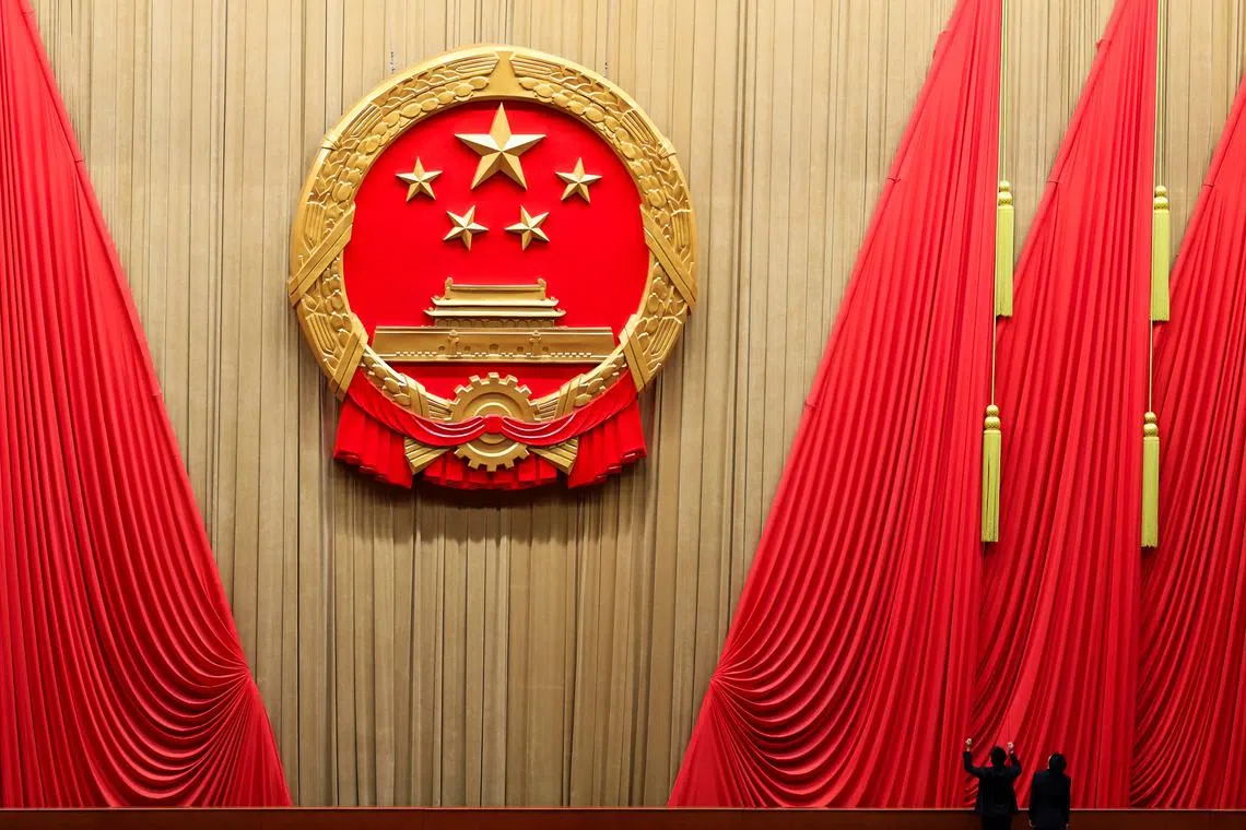 FILE PHOTO: Staff members work inside the Great Hall of the People ahead of the closing session of the National People's Congress (NPC), in Beijing, China March 11, 2024. REUTERS/Tingshu Wang/File Photo