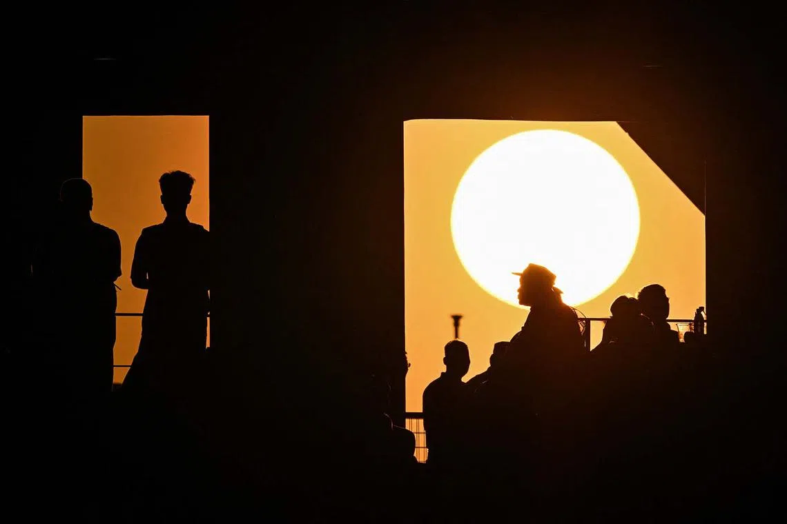 TOPSHOT - The sun sets before the 2026 FIFA World Cup qualification football match between China and Australia at the Hangzhou Olympic Sports Center Stadium in Hangzhou, in China's eastern Zhejiang province on March 25, 2025. (Photo by Hector RETAMAL / AFP)