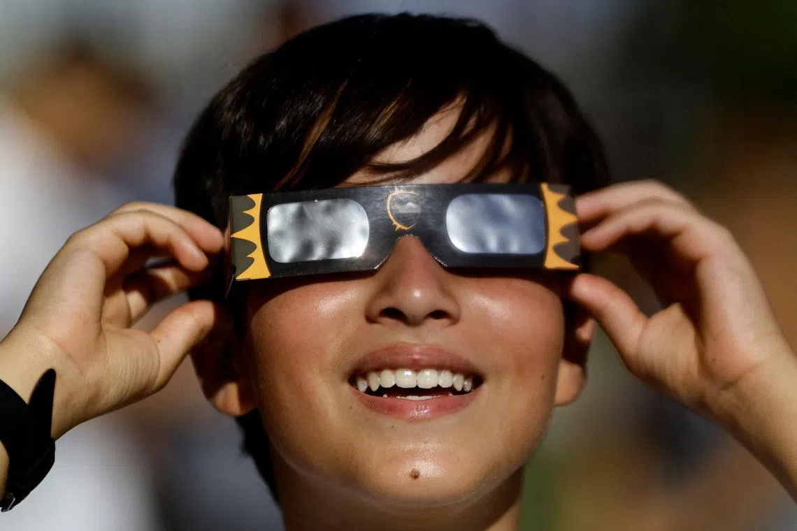 A boy with solar glasses watching the annular solar eclipse in Brasilia, Brazil, on Oct 14, 2023. 