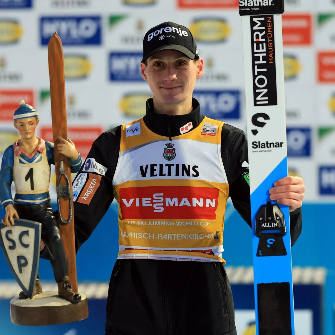 Ski Jumping - Four Hills Tournament - Garmisch-Partenkirchen, Germany - January 1, 2026 Slovenia's Domen Prevc celebrates on the podium with the trophy after winning the Men's Individual HS142 REUTERS/Kai Pfaffenbach