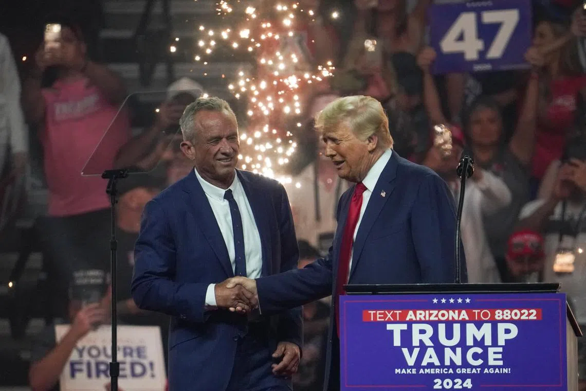 Republican presidential nominee Donald Trump shakes hands with Robert F. Kennedy Jr. during a rally in Glendale, Arizona, on Aug 23.
