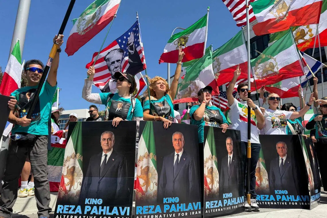 People wave US and pre-revolutionary Iranian flags as they protest the Iranian regime outside the SoFi Stadium in Inglewood, California, on June 7 ahead of the 2026 FIFA World Cup. 
