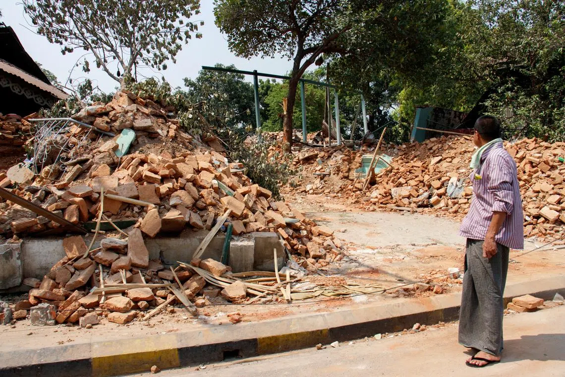 A man stands near debris of a building destroyed in a strong earthquake, in Amarapura, Myanmar, March 31, 2025. REUTERS/Stringer