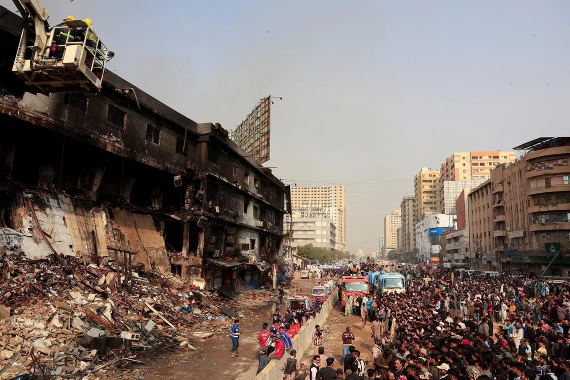 People gather as emergency personnel search for survivors, following a massive fire that broke out in the Gul Plaza Shopping Mall in Karachi, Pakistan, January 19, 2026. REUTERS/Akhtar Soomro