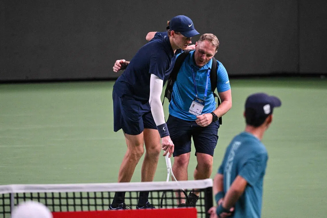 Italy's world No. 2 Jannik Sinner is helped by a medical trainer during his men's singles match against Netherlands' Tallon Griekspoor at the Shanghai Masters tennis on Oct 5, 2025. He was one of seven retirements or walkovers at the tournament, while at the China Open, five of 12 matches ended prematurely during a single day.