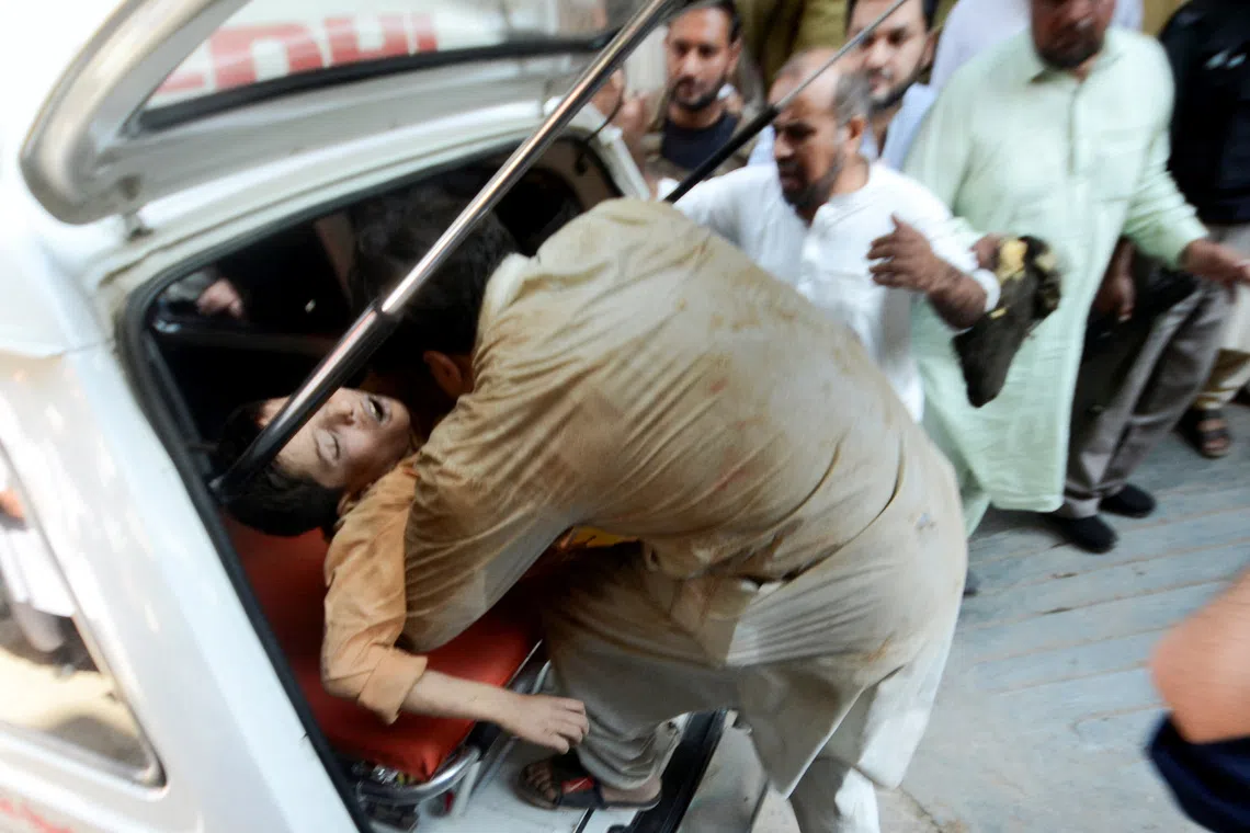A man carries an injured boy after a school roof collapse in Peshawar, Pakistan, on October 15, 2026. REUTERS
