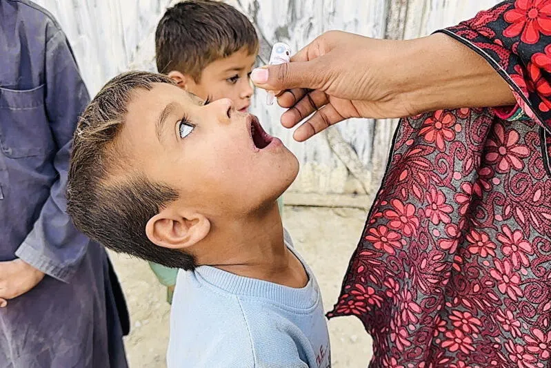 A health worker administers a polio vaccine to a child near the Afghan border in Chaman, Pakistan.