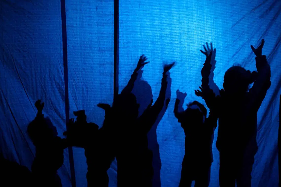 Children are silhouetted as they play in a displacement tent in Khan Yunis in southern Gaza on Nov 11, 2024, amid the ongoing war between Israel and the Palestinian Hamas movement. 