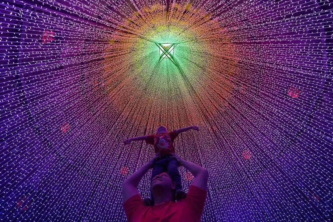 A man and a child posing for a photo with Christmas lights in Medellin, Colombia on Nov 27, 2025. 