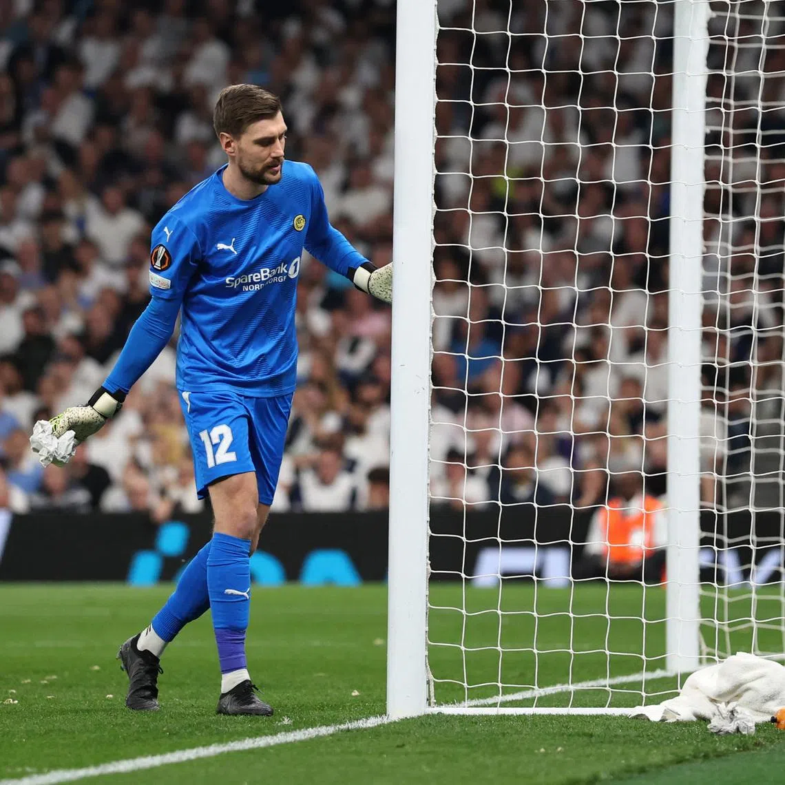 Soccer Football - Europa League - Semi Final - First Leg - Tottenham Hotspur v Bodo/Glimt - Tottenham Hotspur Stadium, London, Britain - May 1, 2025 Bodo/Glimt's Nikita Haikin with an object in his hands that had been thrown onto the pitch by fans REUTERS/David Klein