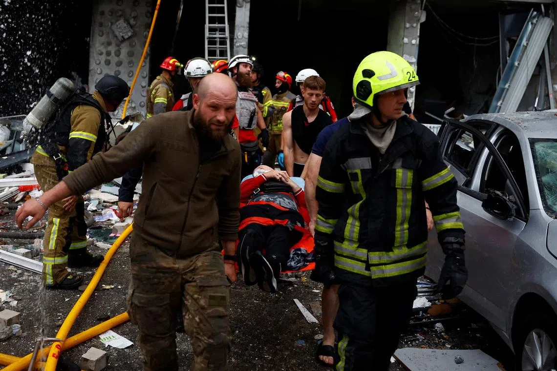 Rescuers carry an injured resident at the site of an apartment building, which was heavily damaged during Russian missile and drone strikes, in Kyiv, Ukraine, on July 6.