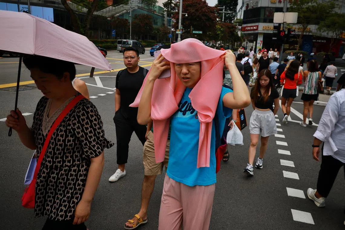 Any form of protection from the heat will do for this pedestrian in Orchard Road on Apr 13, 2023. Singapore is currently in the inter-monsoon period, and it is not uncommon for daily maximum temperatures to exceed 35 deg C.
