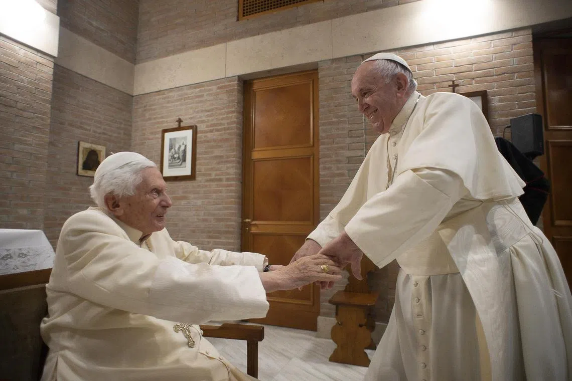 A 2020 photo shows Pope Emeritus Benedict XVI (left) being greeted by Pope Francis, following a ceremony to create new cardinals.