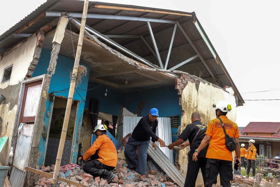 Rescue team help residents to search for valuables from the rubble of their damaged homes following an earthquake at Betungan urban village, Bengkulu Province on May 23, 2025.