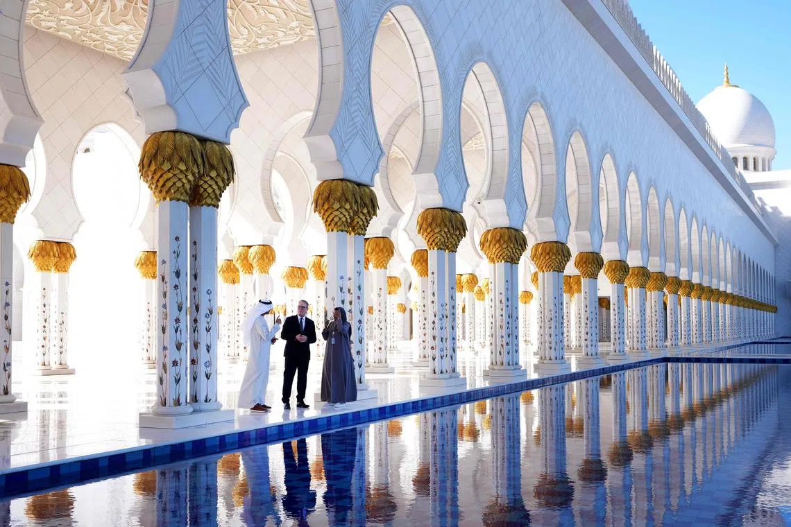 Britain's Prime Minister Keir Starmer (centre) listening to Sheikh Zayed Grand Mosque' director General Yousef al-Obaidli during a visit to the shrine, in Abu Dhabi, on Dec 9, 2024, during his three day visit of United Arab Emirates, Saudi Arabia and Cyprus. 
