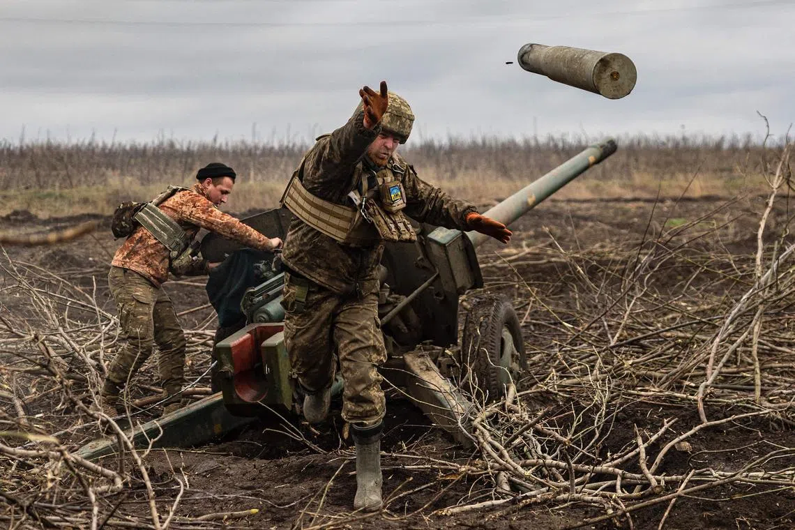 A Ukrainian serviceman throws an empty shell as his artillery unit fires towards Russian positions on the outskirts of Bakhmut, eastern Ukraine, on Dec 30, 2022.