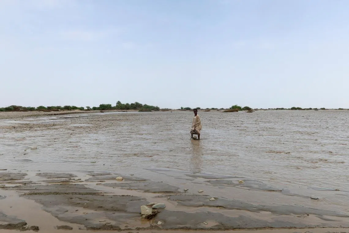 A person walks through flood water, in Port Sudan, Sudan, August 26, 2024. REUTERS/El Tayeb Siddig