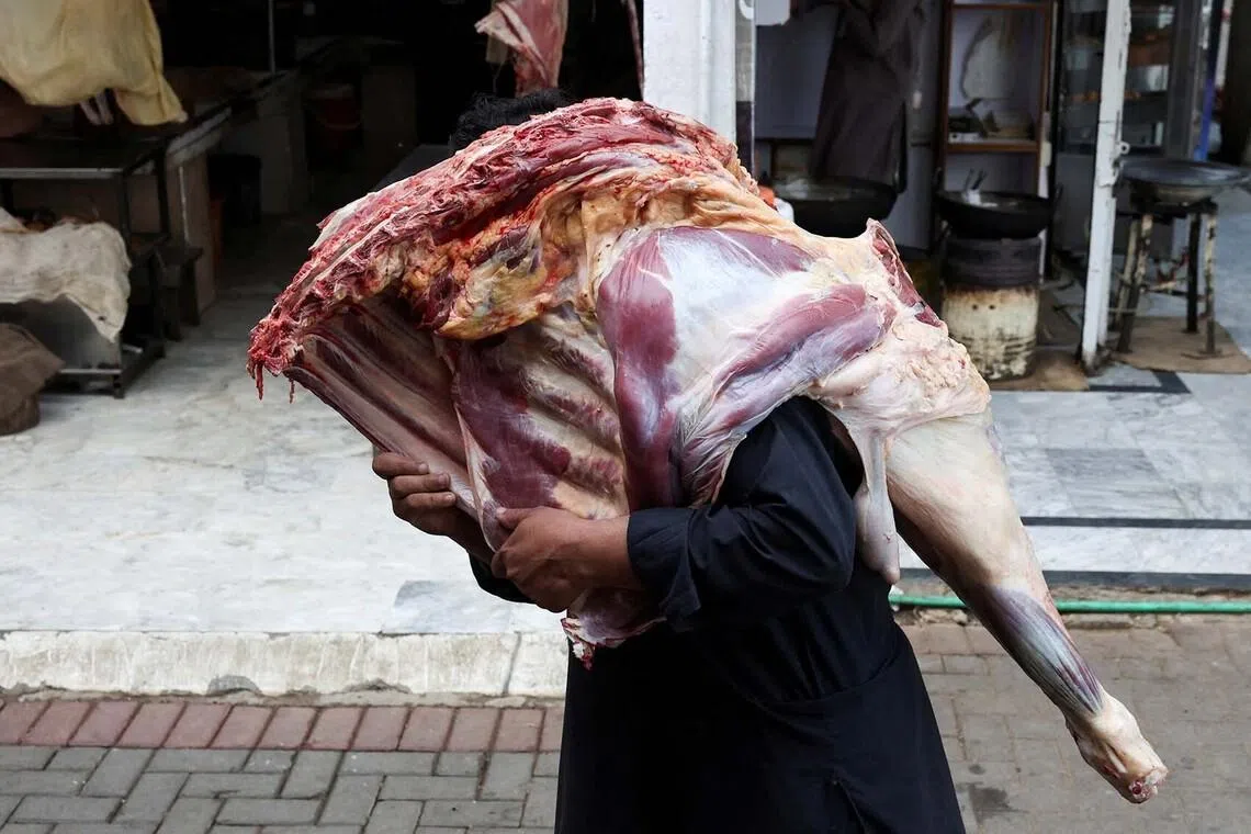 A market worker carrying a large chunk of meat to deliver to a shop in Islamabad, Pakistan, June 15.
