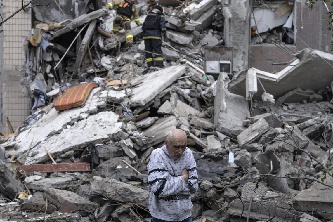 A  man waiting for Ukrainian rescuers and municipal services to find his mother under the rubble of a residential building destroyed on May 7 by an aerial bomb, in Ukraine's front-line city of Kostyantynivka, in the Donetsk region.