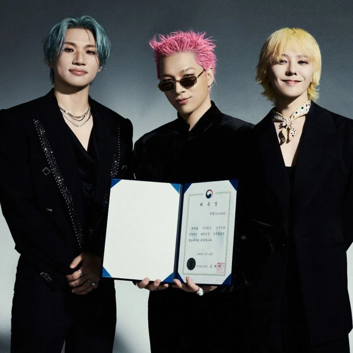 K-pop outfit BigBang posing with their certificate of appointment that designates them as the inaugural honorary ambassadors for the Korea AeroSpace Administration.