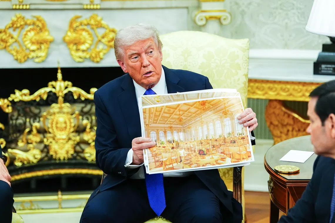US President Donald Trump showing an interior rendering of the new White House Ballroom in the Oval Office of the White House on Oct 22.