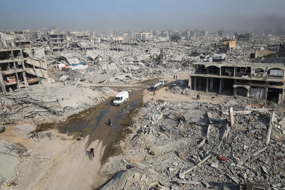 Palestinians walk past the rubble of destroyed buildings, amid a ceasefire between Israel and Hamas, in Gaza City, November 5, 2025. REUTERS/Dawoud Abu Alkas
