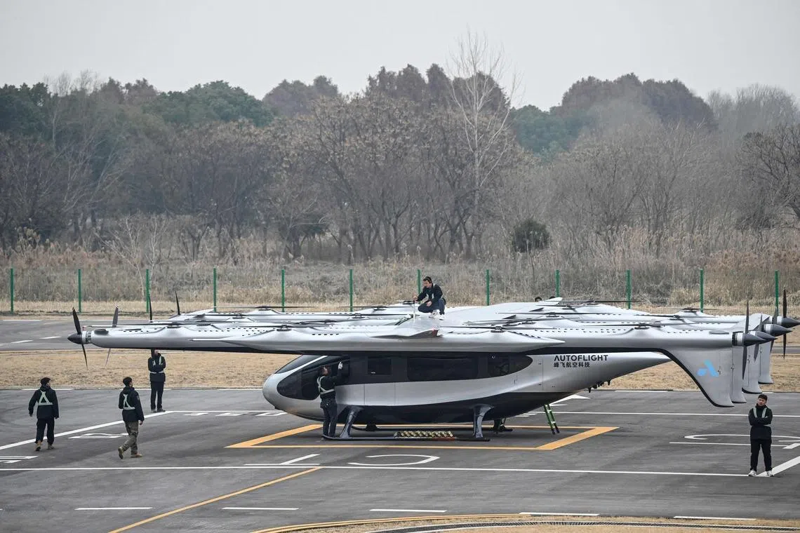 Technicians examining AutoFlight's 5-ton-class V5000 Matrix, a 10-seater electric vertical take-off and landing (eVTOL) aircraft, ahead of a public flight demonstration at the AutoFlight Kunshan Flight Test Base in Kunshan, China on Feb 5, 2026. 