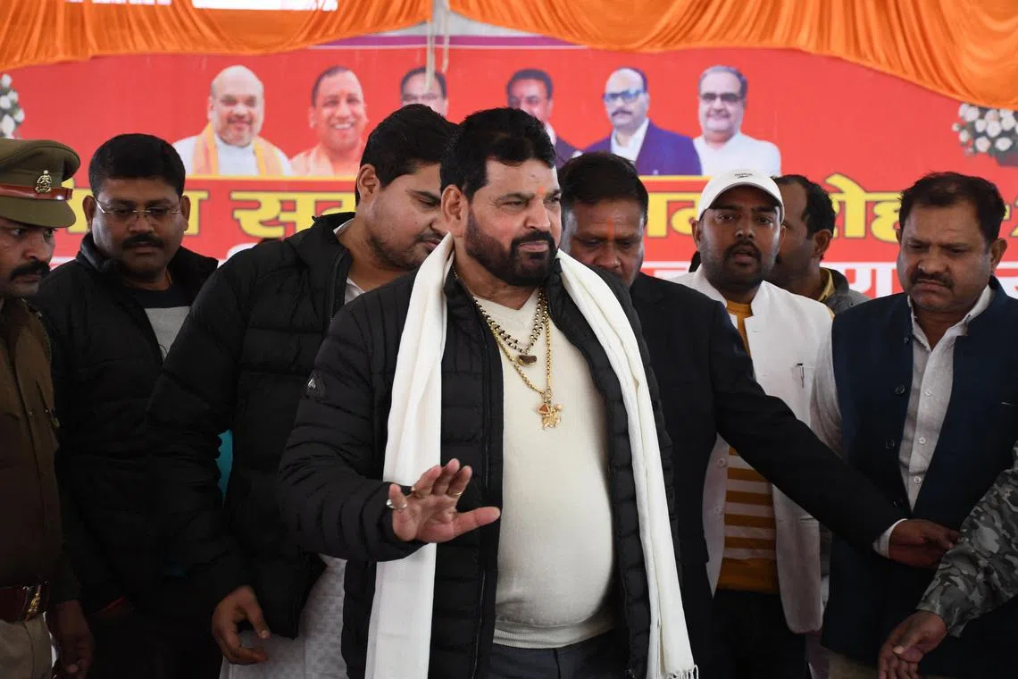 Wrestling Federation of India (WFI) president Brij Bhushan Sharan Singh (C) arrives to address a press conference in Gonda on January 20, 2023, following allegations of sexual harassment to wrestlers by members of the WFI. (Photo by AFP)
