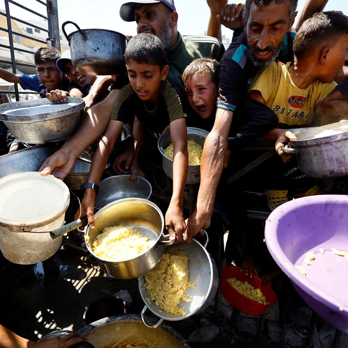 FILE PHOTO: Palestinians wait to receive food from a charity kitchen after the global hunger monitor, in Gaza City, August 28, 2025. REUTERS/Mahmoud Issa/File Photo