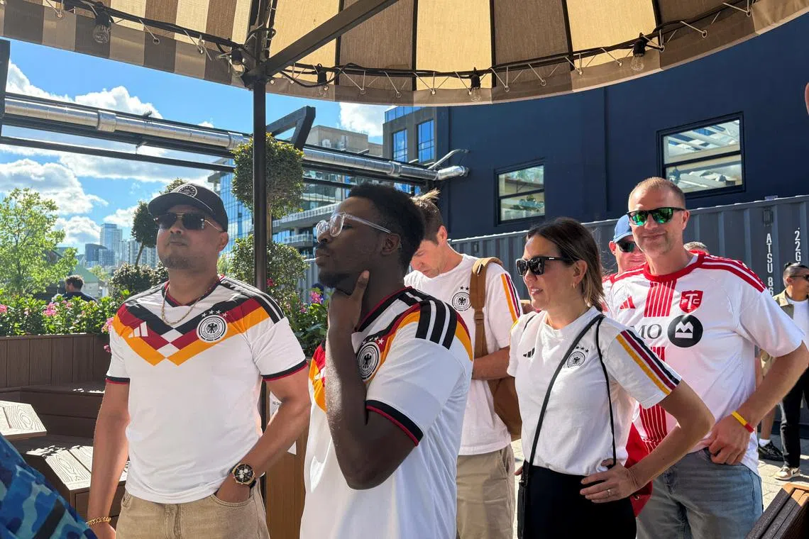 German fans queue outside a downtown pub for a fan party in Toronto.