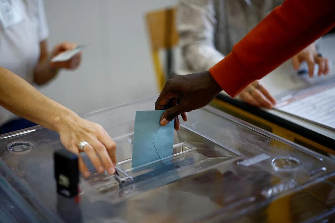 FILE PHOTO: A person casts a ballot in the second round of the early French parliamentary elections, at a polling station in Paris, France, July 7, 2024. REUTERS/Sarah Meyssonnier/File Photo
