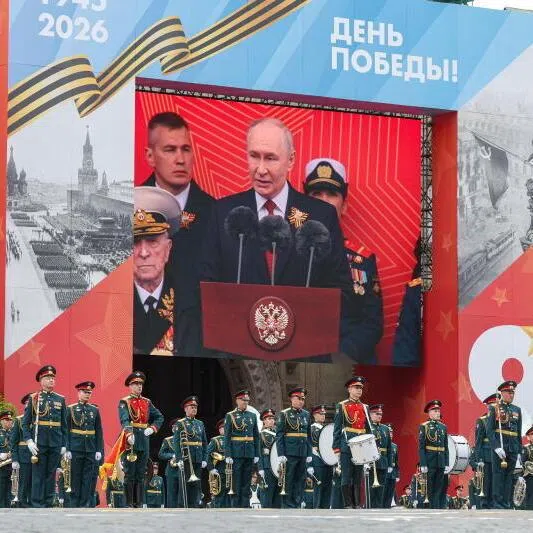 A screen display shows Russian President Vladimir Putin addressing the scaled down Victory Day military parade in Moscow.  