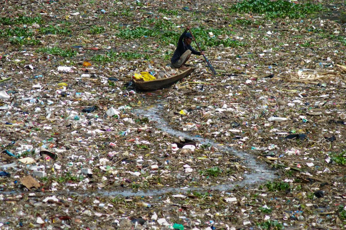 A man collects plastic from the polluted Citarum river in West Bandung on December 14, 2022. 