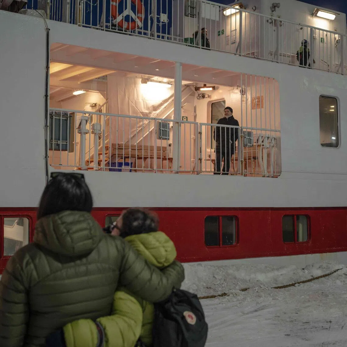 People watch from the ground as their loved ones board the Sarfaq Ittuk ferry at the port of Nuuk, Greenland, on March 13.