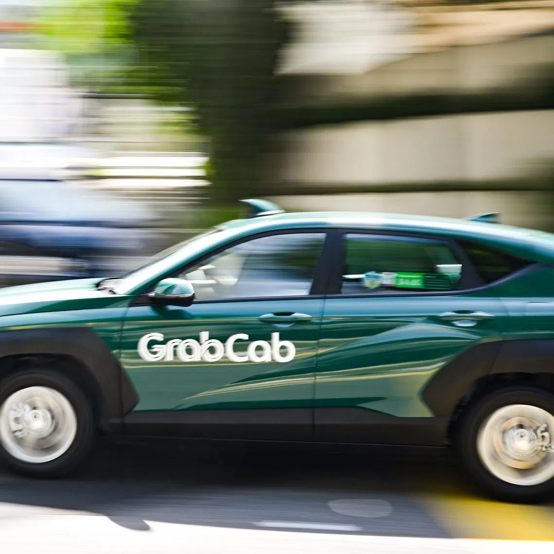 ST20260126-202688000532-Lim Yaohui-pixgeneric/ Generic photograph of GrabCab travelling along Irrawaddy Road on Jan 26, 2026. GrabCab was launched on July 2, 2025 with a flag-off ceremony at Grab’s headquarters in one-north. The taxi operator, a subsidiary of Grab’s rental arm GrabRentals, announced its entry into the market on June 4, 2025, with 40 new fifth-generation electric hybrid Toyota Prius cars. Under the terms of its street-hail operator licence, GrabCab has three years to progressively expand its fleet to meet the minimum fleet size requirement of 800 cabs. (ST PHOTO: LIM YAOHUI)