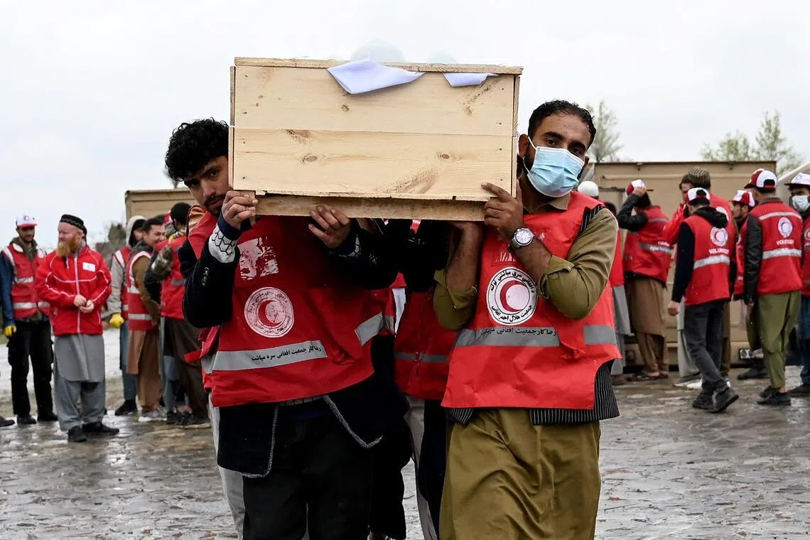 Afghan Red Crescent Society volunteers carry coffins of victims of a Pakistani air strike on a drug rehabilitation centre, during a mass burial at the Badam Bagh Hilltop in Kabul on March 18.
