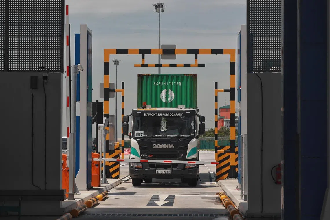 A container truck about to pass through the Radiographic Scanning Portal at Tuas Port on 18 Apr 2022. Immigration and Checkpoints Authority (ICA) has been progressively implementing new initiatives at Tuas Port, with the aim of providing visitors with a seamless and more secure cargo clearance experience. The radiographic scanning portal scans cargo for anomalies as vehicles go through it.
