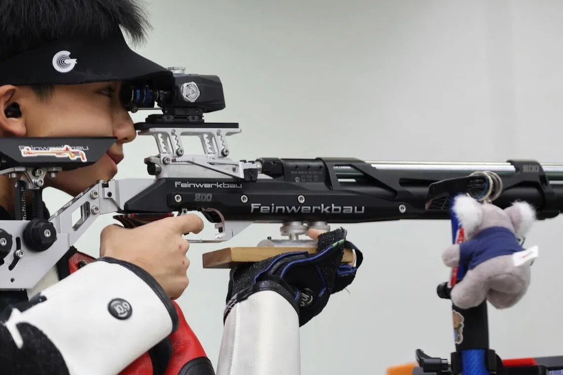 Matthew Cheong from Raffles Institution taking aim with his lucky Koala Bear keychain during the National School Games Men's 10m Air Rifle final held at the Safra Indoor Air Weapon Range on April 10, 2026