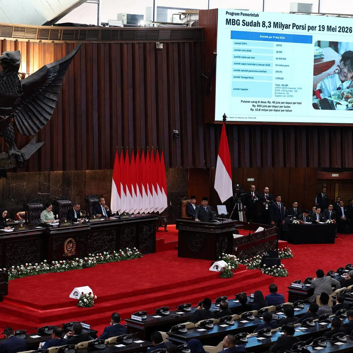 Indonesian President Prabowo Subianto delivers a speech on May 20 as a screen shows progress of his flagship free nutritious meals programme.