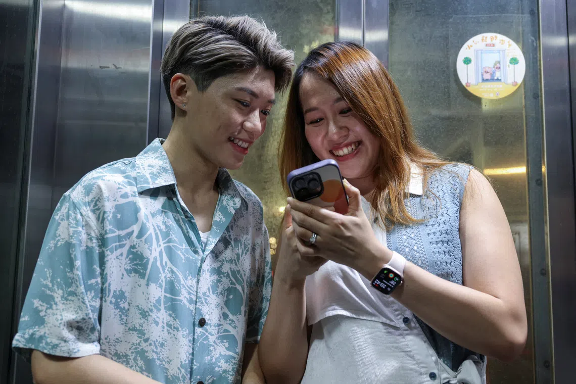 Gloria Tsang, a 33-year-old speech therapist, and her wife Jaedyn Yu, a 35-year-old drum school owner, react in a lift in Hong Kong, China, September 12, 2025. REUTERS/Tyrone Siu