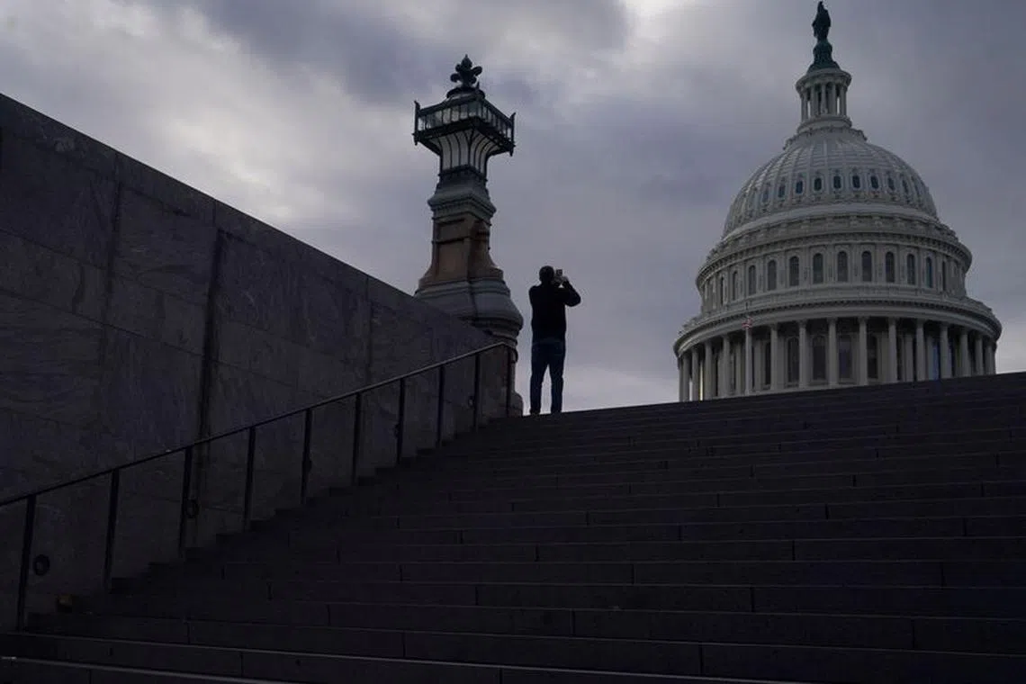 FILE PHOTO: A man uses his mobile phone near the U.S. Capitol in Washington, U.S., January 10, 2024. REUTERS/Nathan Howard/File Photo