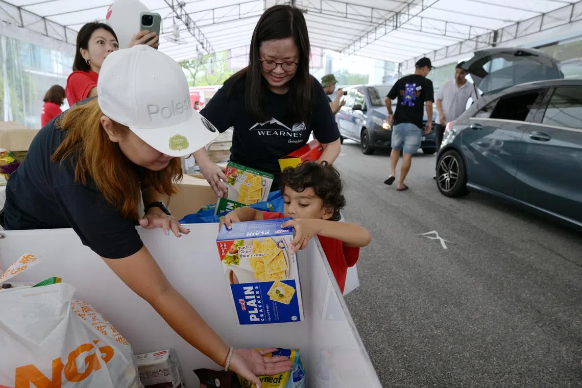 Three-year-old Devan Joshi donating food on March 2, 2024 at Food From The Heart's second Drive-Thru Food Donation Drive, Heart On Wheels, this weekend. The food donation drive aims to raise 25,000 food items and members of the public have three ways to support Heart On Wheels, one of which being driving directly to the event to donate.