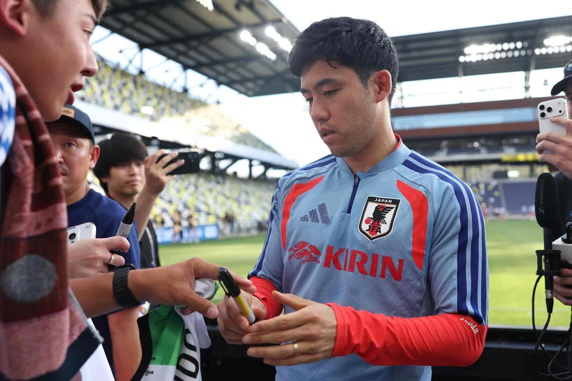 Japan's Wataru Endo signing autographs for fans during an open training session in Nashville on June 8.
