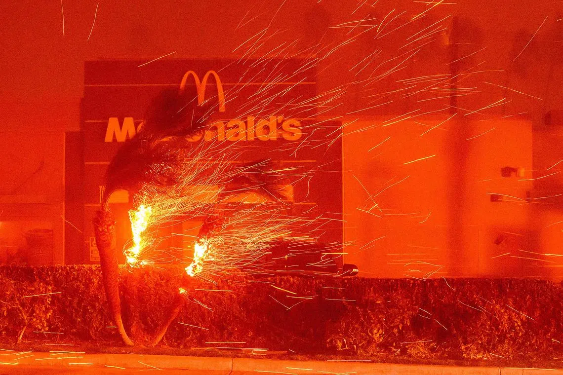 A McDonald's restaurant is showered in embers during the Eaton wildfire in Los Angeles county on Jan 7, 2025. 