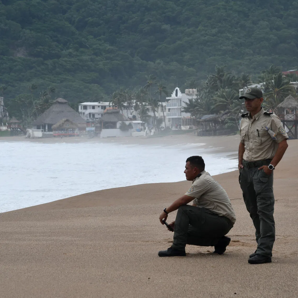 Jalisco Civil Protection personnel stand on a beach as Hurricane Polo, last classified as a Category 4 storm, moves northwest offshore, in Melaque, Jalisco state, Mexico, September 24, 2026. REUTERS/Liberto Urena