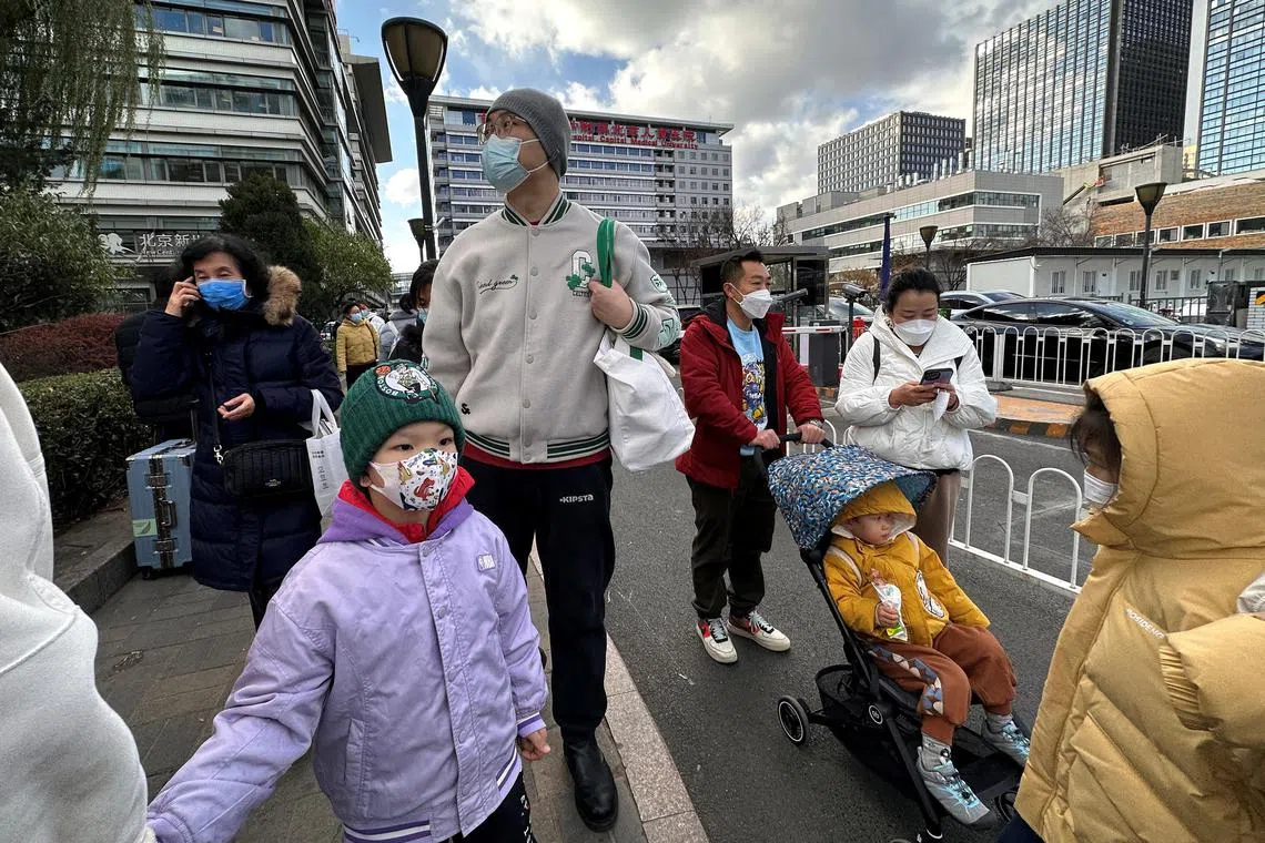 People leaving a hospital in Beijing, China, amid a spike in respiratory illness cases among children.